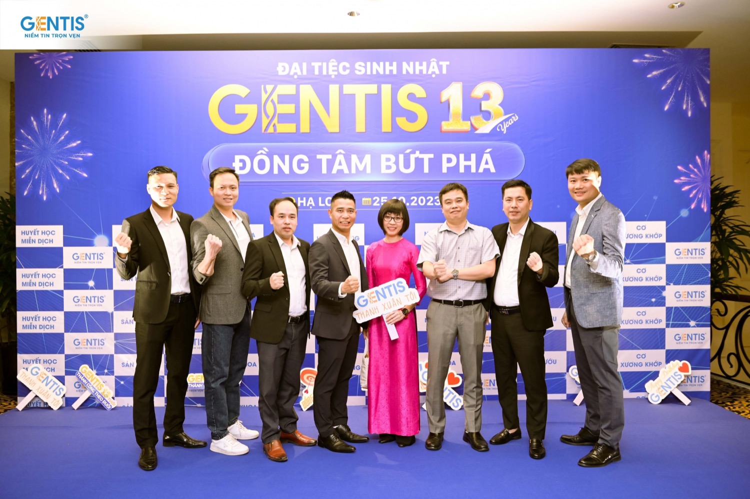Seven attendees in front of the GENTIS 13th anniversary backdrop